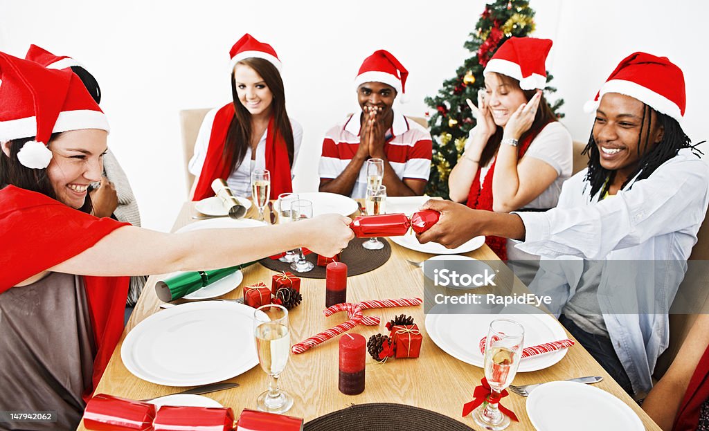 Felices jóvenes anticipar el bang de una galleta de navidad - Foto de stock de 20 a 29 años libre de derechos
