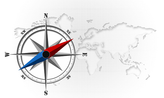 A compass on the world map with a white dotted background with a copy space