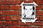 "Missing" poster of teenage girl taped to red brick wall
