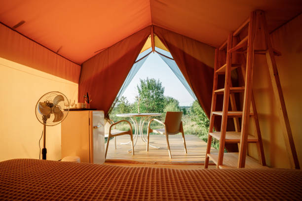istock Interior of Cozy open glamping tent with light inside during sunset. Luxury camping tent for outdoor summer holiday and vacation. Lifestyle concept 1479422096