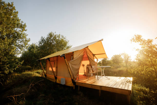 istock Cozy open glamping tent with light inside during sunset. Luxury camping tent for outdoor summer holiday and vacation. Lifestyle concept 1479422297