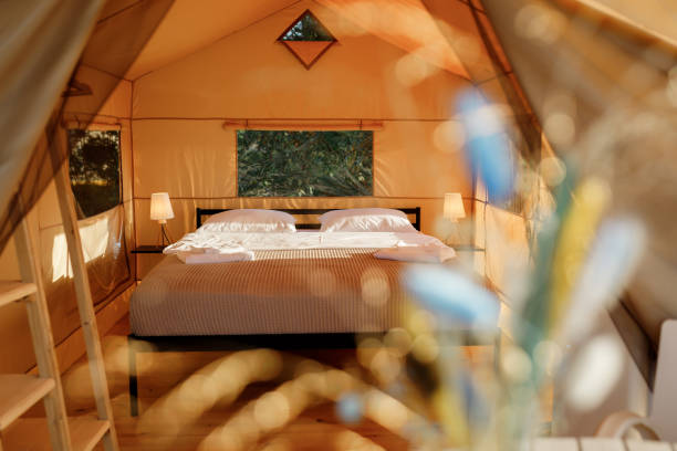 istock Interior of Cozy open glamping tent with light inside during sunset. Luxury camping tent for outdoor summer holiday and vacation. Lifestyle concept 1479423072