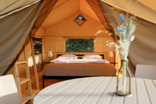 istock Interior of Cozy open glamping tent with light inside during sunset. Luxury camping tent for outdoor summer holiday and vacation. Lifestyle concept 1479423318