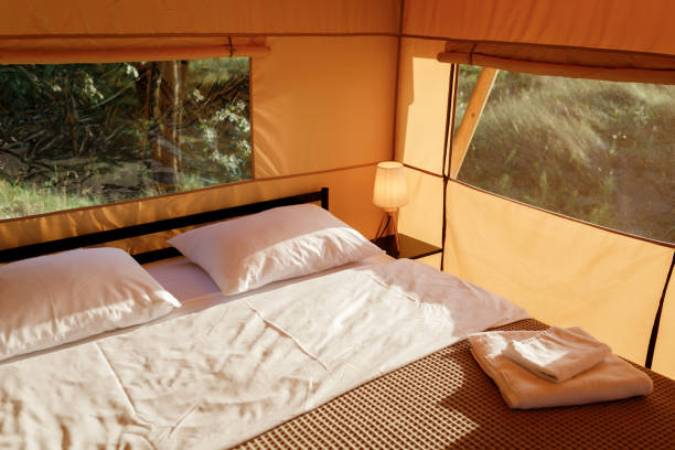 istock Interior of Cozy open glamping tent with light inside during sunset. Luxury camping tent for outdoor summer holiday and vacation. Lifestyle concept 1479423319