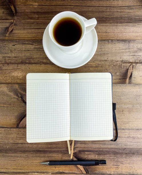 istock Coffee in a cup, notebook and pen. Vertical photo. 1479424823
