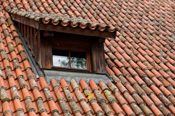 An old red-tiled rooftop with a window in German village, idyllic rural scene