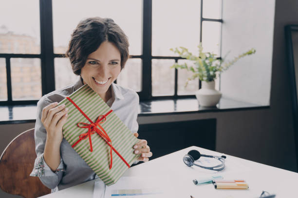 istock Cheerful lady office employee looking at screen broadly smiling showing to computer camera Xmas gift 1479427602