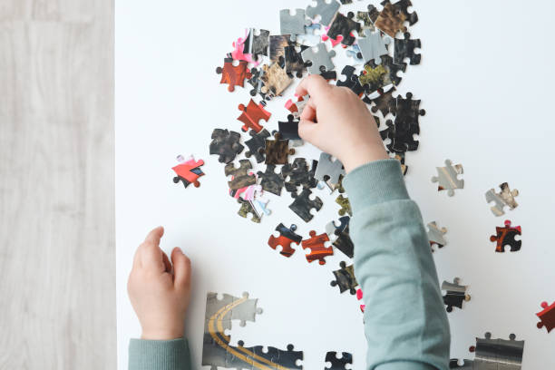 istock Hands of a child doing a puzzle at table 1479427975