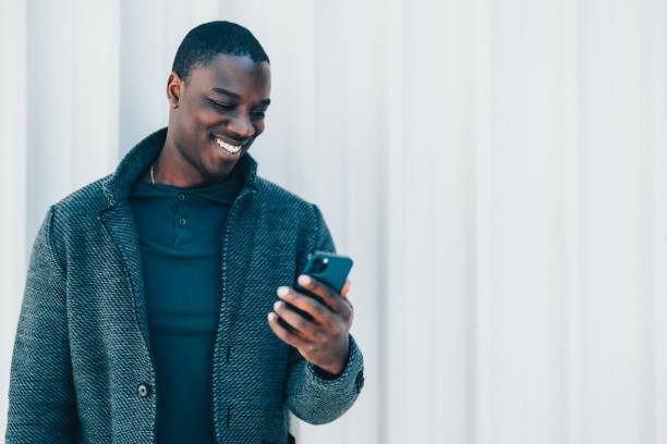 African-american man texting on phone stock photo
