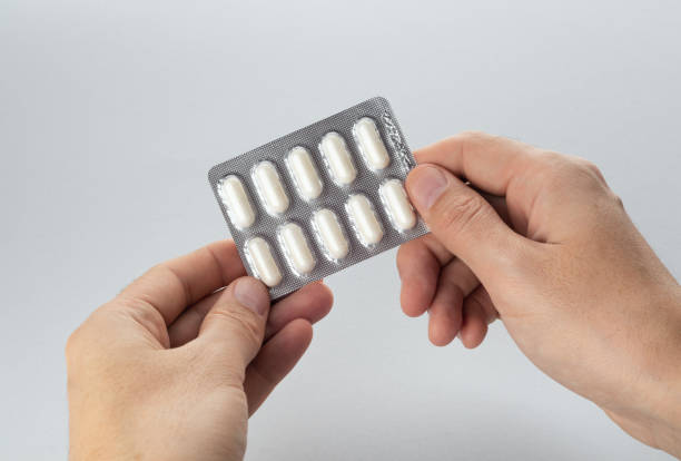 istock Hands holding a blister of pills on a grey background. 1479433038