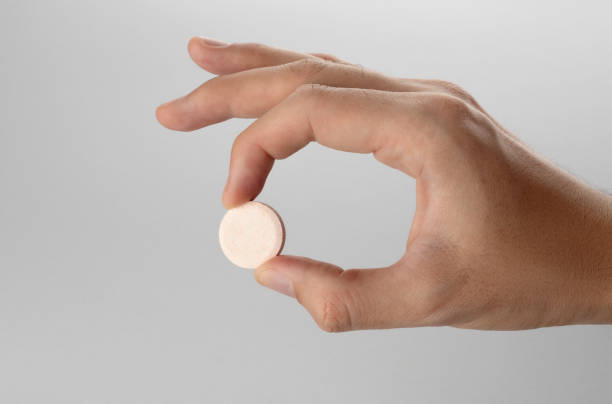 istock Male hand holding effervescent tablet in hand on grey background. 1479433608