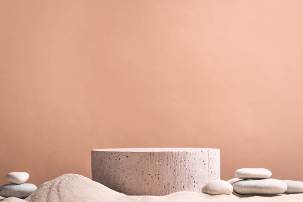 Stone podium and pebbles on sand