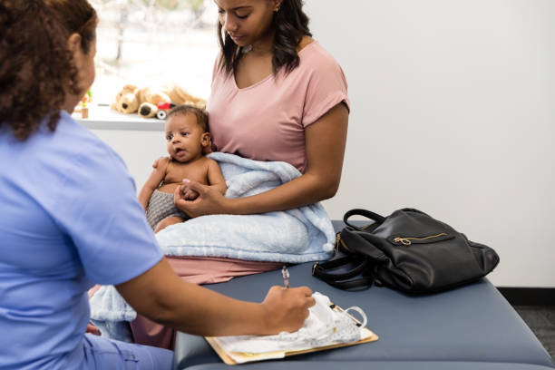 istock Young mom and unrecognizable female doctor both look at baby 1479437086