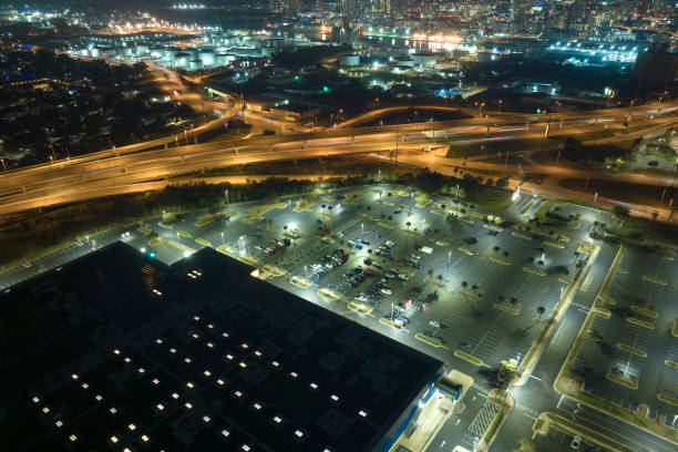 aerial night view of place for vehicles in front of a shopping mall in tampa. many cars parked on parking lot with lines and markings for parking places and directions - street light parking lot night lot imagens e fotografias de stock