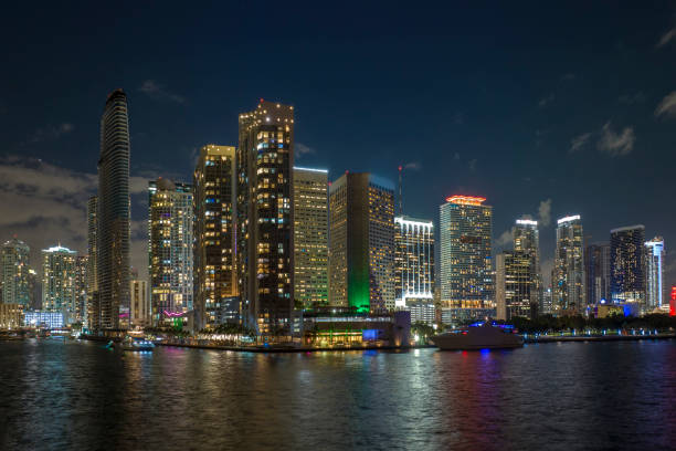 View from above of brightly illuminated high skyscraper buildings in downtown district of Miami Brickell in Florida, USA. American megapolis with business financial district at night