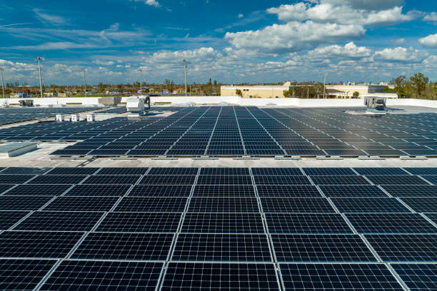 vue aérienne d’une centrale solaire avec des panneaux photovoltaïques bleus montés sur le toit d’un bâtiment industriel pour produire de l’électricité écologique verte. concept de production d’énergie durable - environmental conservation built structure solar power station building exterior photos et images de collection