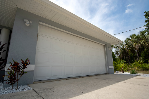 Wide garage double door and concrete driveway of new modern american house.