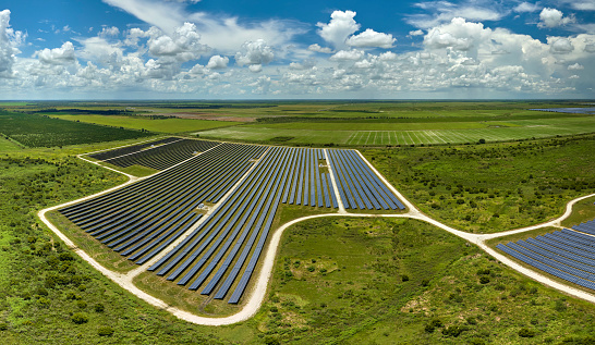 Aerial view of large sustainable electrical power plant with rows of solar photovoltaic panels for producing clean electric energy. Concept of renewable electricity with zero emission.