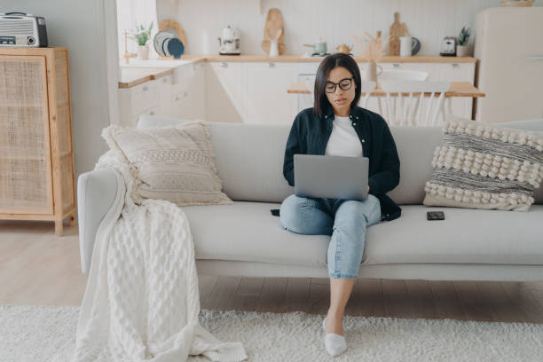 istock Concentrated girl typing on laptop, working from home. Comfortable workplace in modern apartment. 1479437632