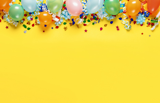 High angle view of confetti colored papers background on yellow paper