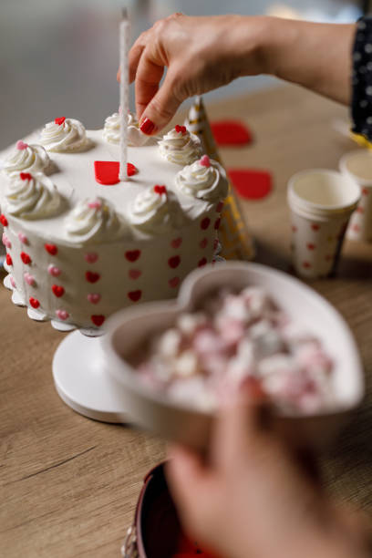istock Woman decorating a birthday cake with heart shaped candy 1479438492