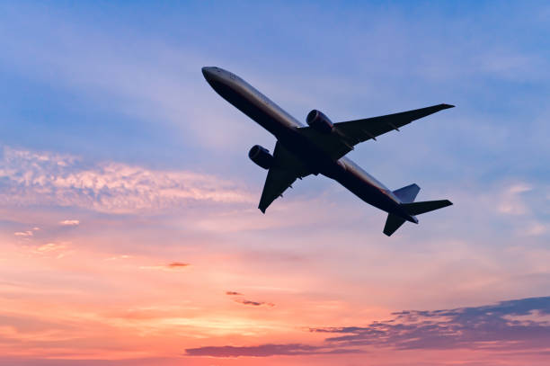 istock Passenger jetplane flying above clouds in sunset. Beautiful sunset scenery, transportation and fast travel concept. 1479440618