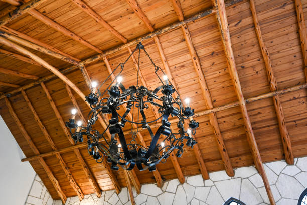 Wrought iron chandelier handing from a wooden ceiling