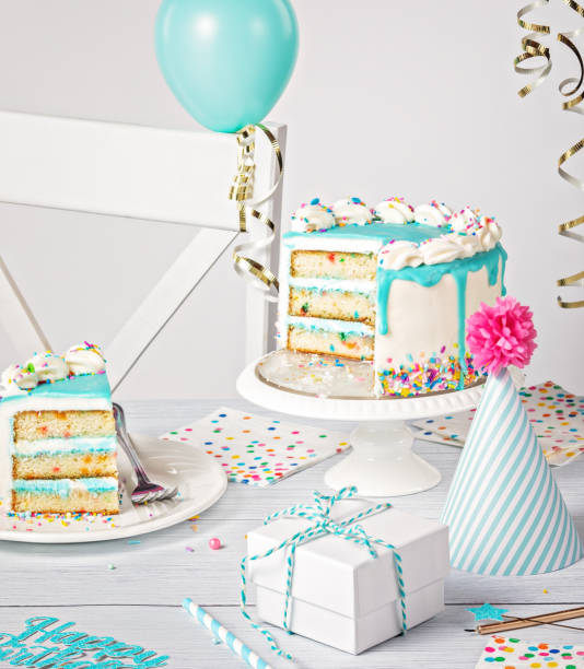 istock Birthday party setting with slice of cake and decorations on a light grey white background 1479449635