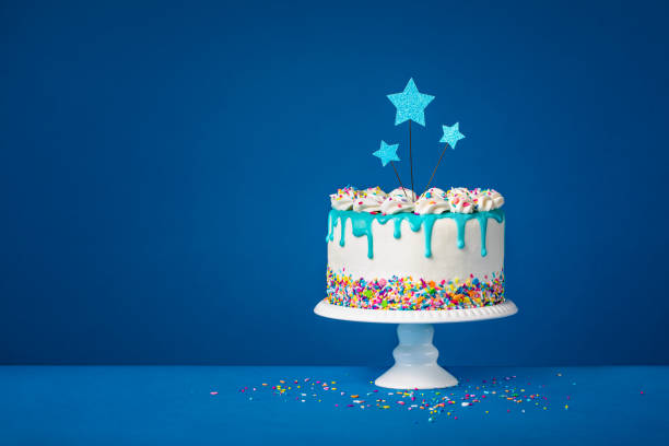 濃い青の背景に白い誕生日のドリップケーキとティールガナッシュ、スタートッパー