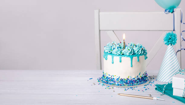 istock Blue Birthday cake, hats and balloons over white background. 1479449743