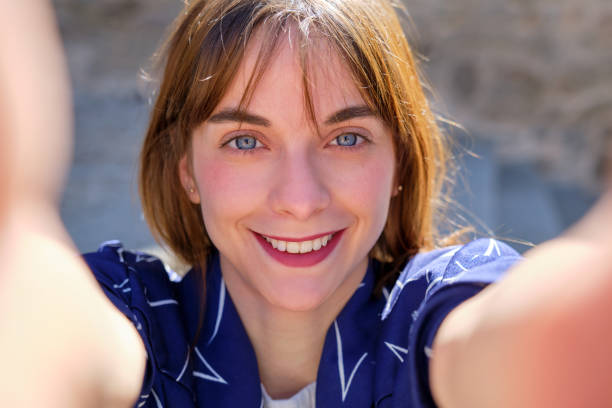 istock smiling pretty young girl with blue eyes taking a selfie illuminated by sunlight 1479451272