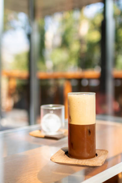 istock Iced coffee glass on table with soft sunlight on garden background. Espresso mixed with lime juice with sliced lime. 1479452479