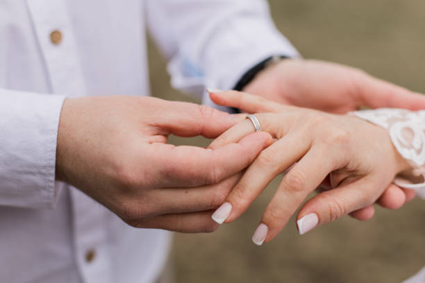 istock the groom puts a gold wedding ring on the bride's finger 1479454206