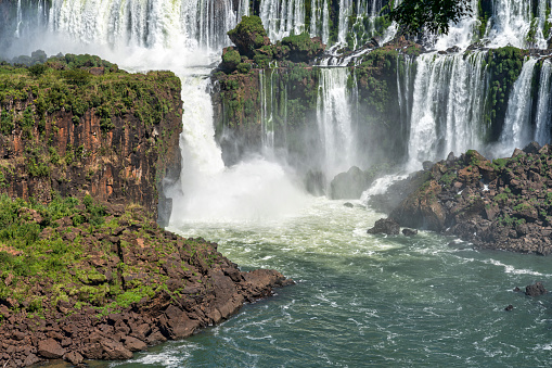 Experience the awe-inspiring beauty of Iguazu Falls, captured in this stunning photo. Located on the border of Brazil and Argentina, these iconic waterfalls are one of the natural wonders of the world, boasting breathtaking views and a powerful roar that can be heard from miles away. The cascading water and lush surrounding greenery create a mesmerizing sight that draws visitors from around the globe. This image is a must-have for anyone interested in nature, adventure, or travel, and is perfect for use in educational or tourism materials.