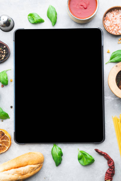 istock Digital tablet computer with mockup white screen on vegetarian healthy food vegetable background. 1479458583