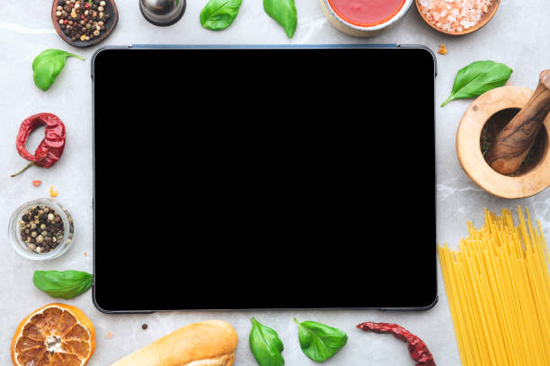 istock Digital tablet computer with mockup white screen on vegetarian healthy food vegetable background. 1479458584