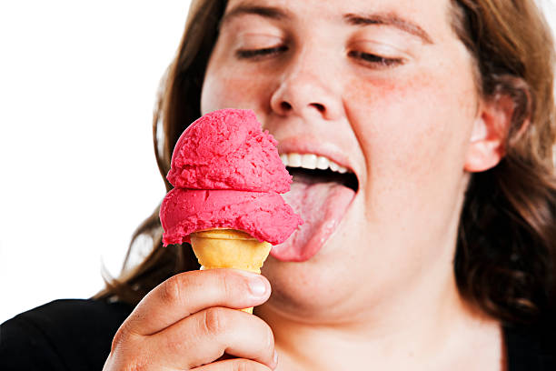 istock Plump young woman lovingly licks an ice cream cone 147946039