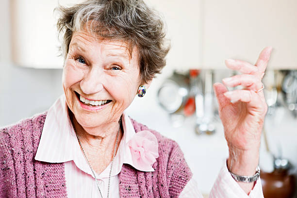 istock Happy old lady smiles and points at something 147946102