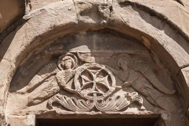 Photo of Stone carvings with cross. Exterior details of Jvari Monastery. Georgia