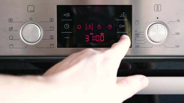 istock Close up of human hand adjusting cooking mode on oven panel in kitchen. The man sets the temperature and timer on the control panel on the oven. 1479463989