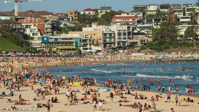 Time lapse of Crowd people visiting and relaxing at iconic Bondi Beach with sunshine during the summer weekends in Sydney, New South Wales, Australia