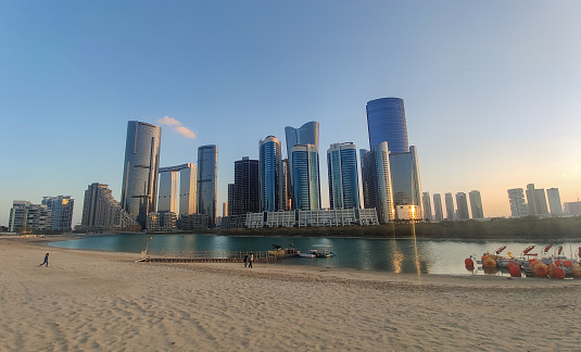 Reem Island central park with modern skyscrapers background in Abu Dhabi in United Arab Emirates during sunset