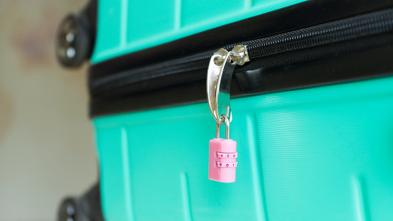 Pink combination lock on suitcase. Image with selective focus