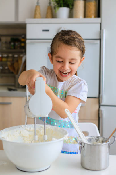 istock Little girl having fun mixing icing in the kitchen 1479482329
