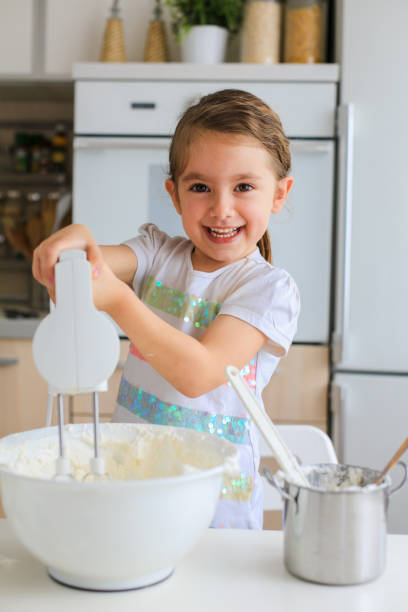 istock Little girl having fun mixing icing in the kitchen 1479482371
