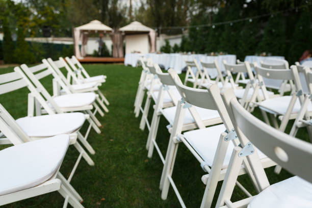 istock Wedding chairs set up before the ceremony. Rows of white empty chairs on a lawn before a wedding or ceremony. 1479482502