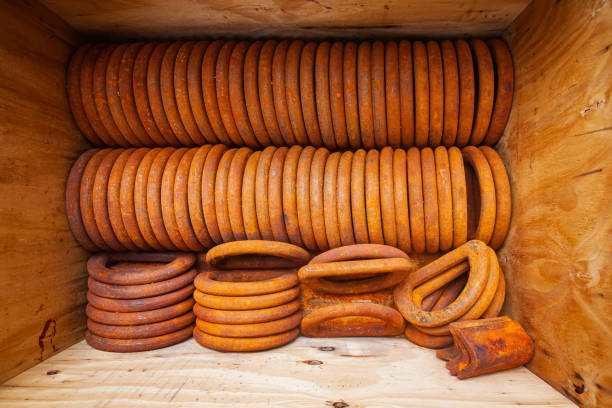 Rusty steel rings stacked in a box for securing loads, top view.