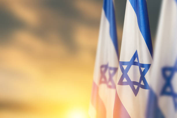 israel flags with a star of david over cloudy sky background on sunset. banner with place for text. - israël stockfoto's en -beelden