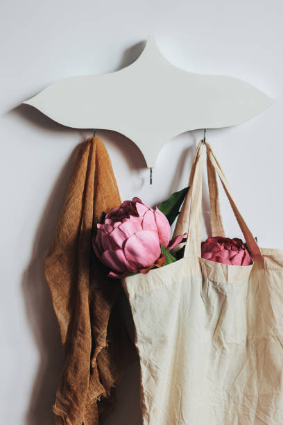 Hanger, towel and shopping bag with flowers. Beautiful handmade wooden hanger. Decorative hanger for home stock photo