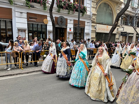 Valencia, Comunidad Valenciana, Spain - March 18, 2023: Several of the thousands of women and men Falleros and Falleras who parade down the streets dressing a traditional Fallas wear going to \